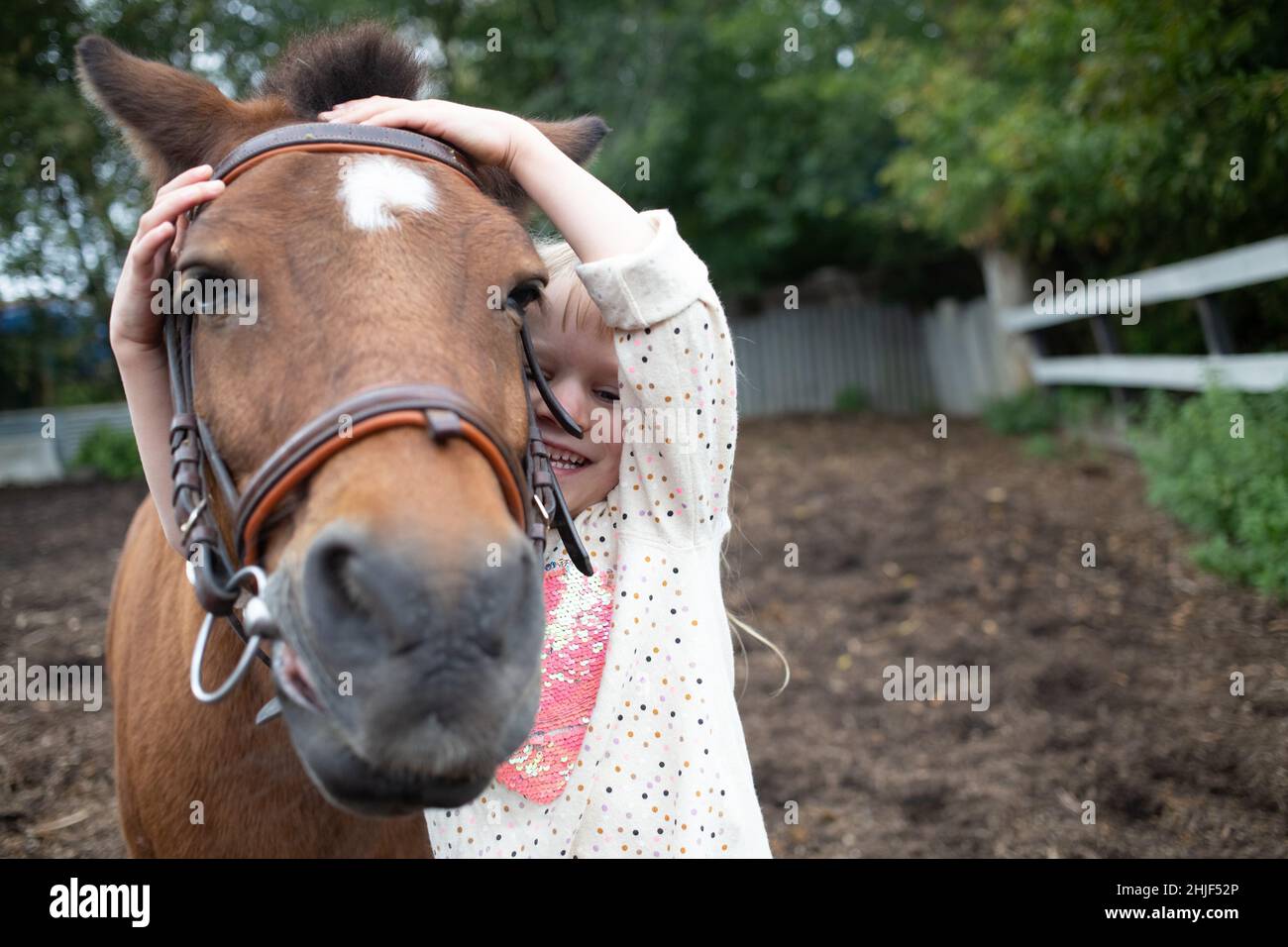 Mädchen umarmt Pony Pferd Schnauze auf Ranch Stockfoto