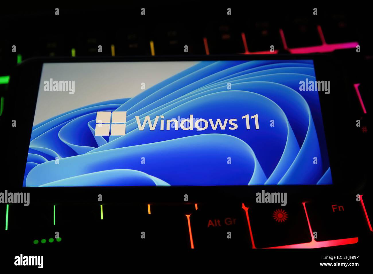 Viersen, Deutschland - Januar 9. 2022: Nahaufnahme des Mobiltelefons mit Logo-Schriftzug des Betriebssystems Windows 11 auf der Computertastatur Stockfoto