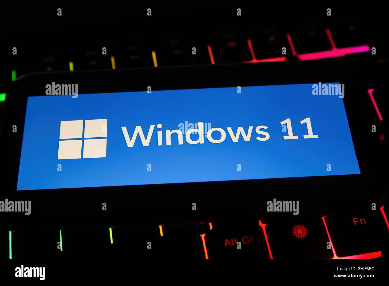 Viersen, Deutschland - Januar 9. 2022: Nahaufnahme des Mobiltelefons mit Logo-Schriftzug des Betriebssystems Windows 11 auf der Computertastatur Stockfoto