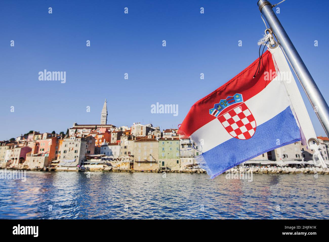 Flagge Kroatiens mit Rovinjer Stadt im Hintergrund, Istrien, Kroatien. Tourismus-Konzept. Urlaub in Kroatien Stockfoto
