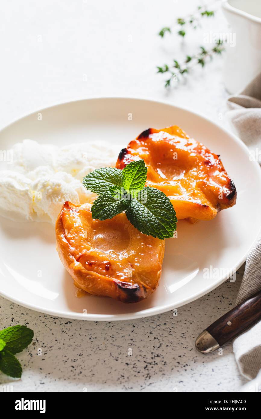 Apfelquitte mit Honig auf einem weißen Teller mit Eis gebacken. Gesundes vegetarisches Dessert. Stockfoto