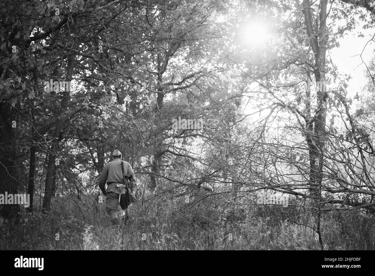 Re-enactor verkleidet als Soldat der russischen sowjetischen Roten Armee des Zweiten Weltkriegs, der mit Waffen durch den Herbstwald läuft. Soldat des Zweiten Weltkriegs WW2 Mal Stockfoto
