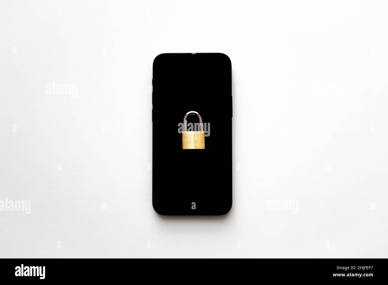 Ein isoliertes schwarzes Smartphone mit einem kleinen Vorhängeschloss auf weißem Hintergrund. Idee zum Telefonschutz. Online-Datenschutzkonzept. Stockfoto