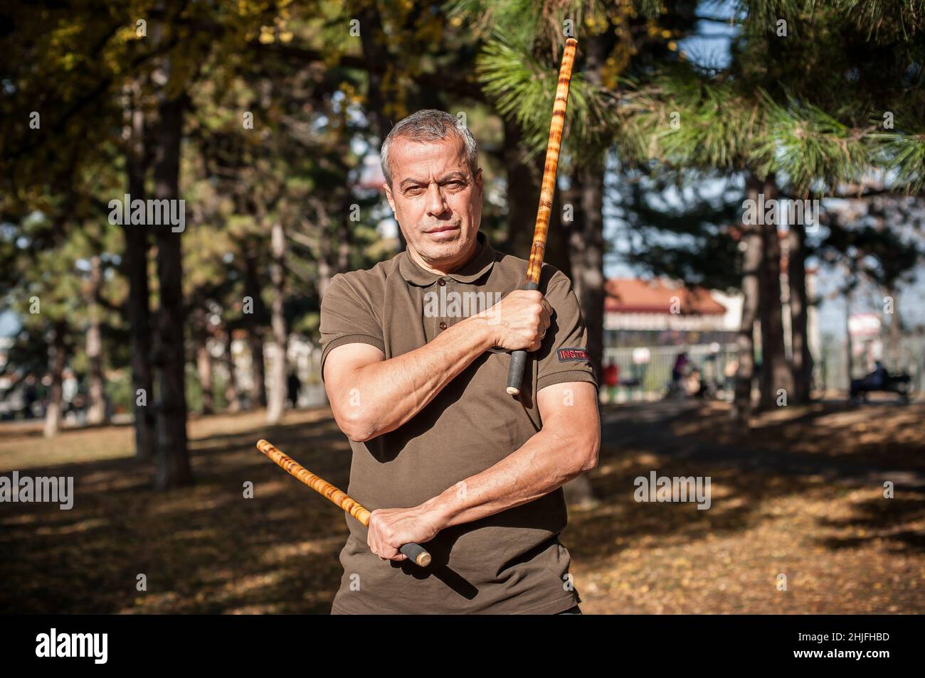 Escrima und Kapap Instruktor demonstriert Stöcke Kampftechniken im öffentlichen Park. Philippinische Kampfkunst. Eskrima. Kali. Stockfoto