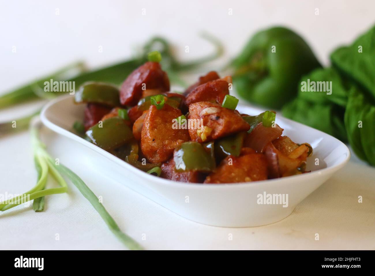 Idli Manchurian. Ein indochinesisches Fusionsküche, das mit übrig gebliebenen Idlis, Paprika und Frühlingszwiebeln hergestellt wird. Vorbereitet durch Schneiden von übrig gebliebenen Idlis in kleine Müllcontainer Stockfoto