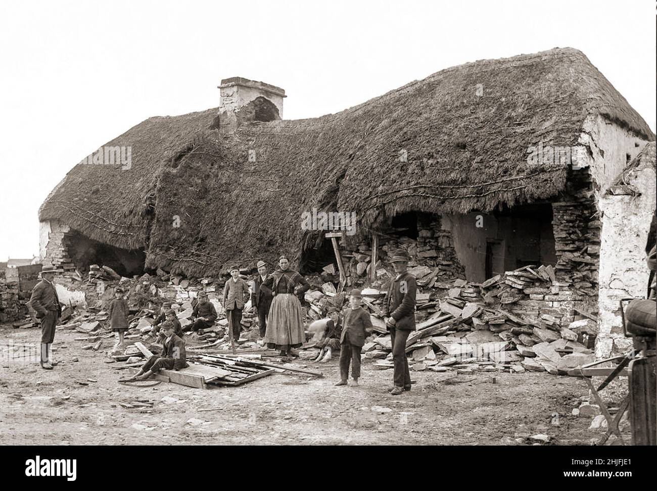 Ein Vintage-Foto der Räumung einer irischen Familie aus dem Jahr 1888 in Moyasta, County Clare, nachdem ein Rammbock verwendet wurde. Vermieter, deren Land mit ärmeren Mietern überfüllt war, wurden jetzt mit hohen Tarifen konfrontiert und viele begannen, die armen Mieter von ihren kleinen Grundstücken zu räumen. Die große Masse an Zwangsräumungen kam im Jahr 1840s, und als die Polizei begann, eine Zählung zu halten, verzeichneten sie insgesamt fast 250.000 Personen, die zwischen 1849 und 1854 offiziell vertrieben wurden. Die Räumungen dauerten bis zum 1890s. Stockfoto