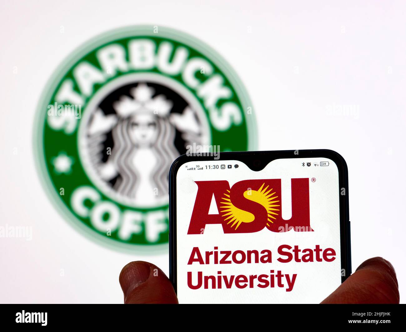 In dieser Fotobilder wird das Logo der Arizona State University auf einem Smartphone-Bildschirm mit dem Starbucks Kaffee-Logo im Hintergrund angezeigt. Stockfoto