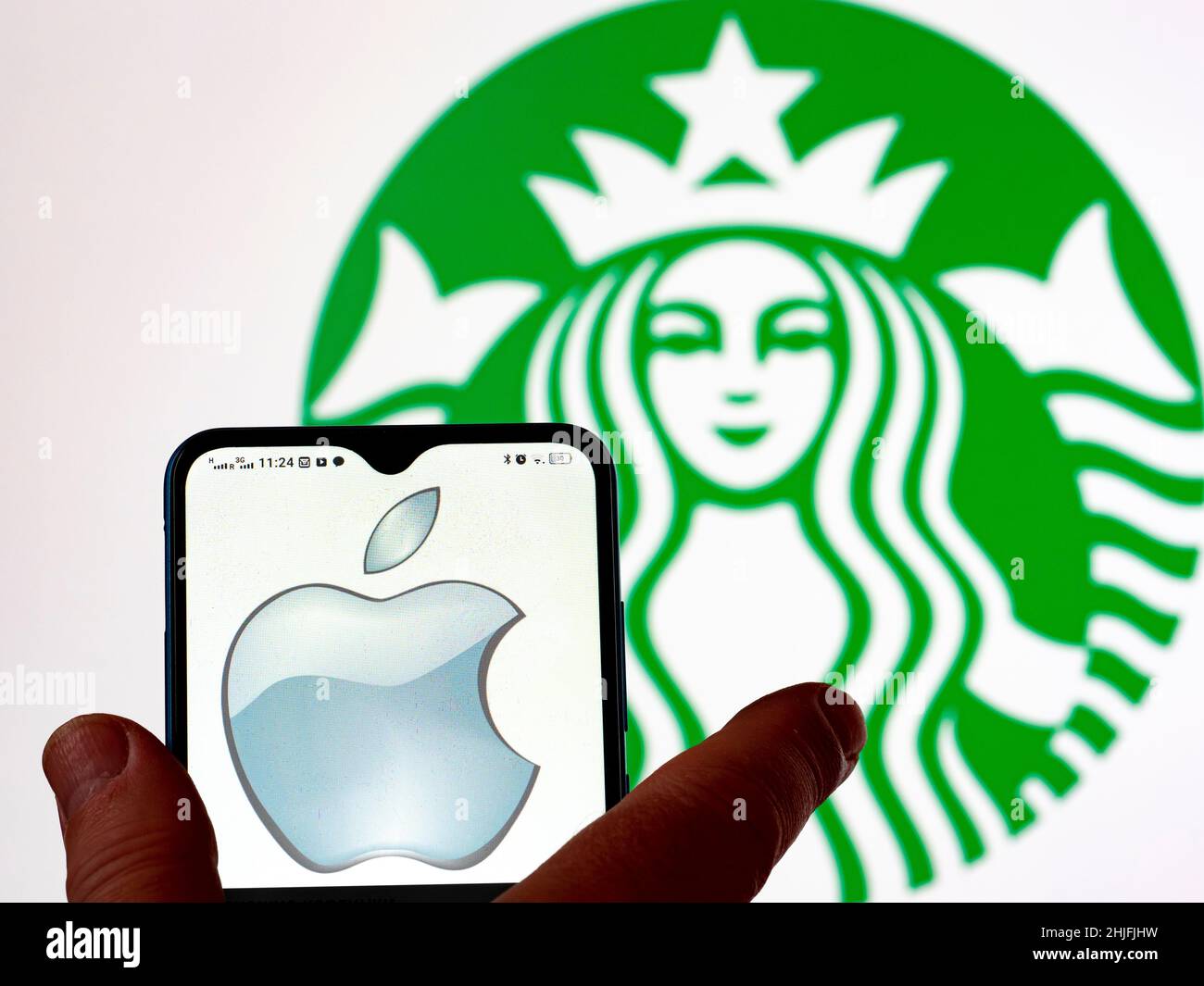 In dieser Abbildung ist das Logo von Apple Inc. Auf einem Smartphone-Bildschirm mit dem Starbucks Kaffee-Logo im Hintergrund zu sehen. Stockfoto