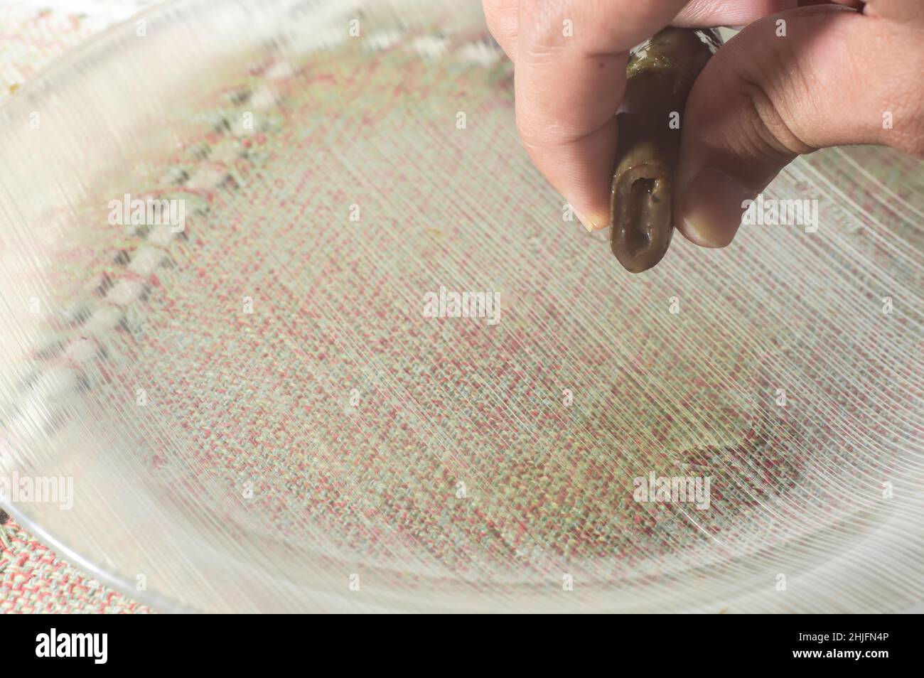 Jalapeno-Pfeffer auf einem Teller mit mao-Holding, eingelegter Pfeffer wird zerknittert, kopieren Sie Platz links. Stockfoto