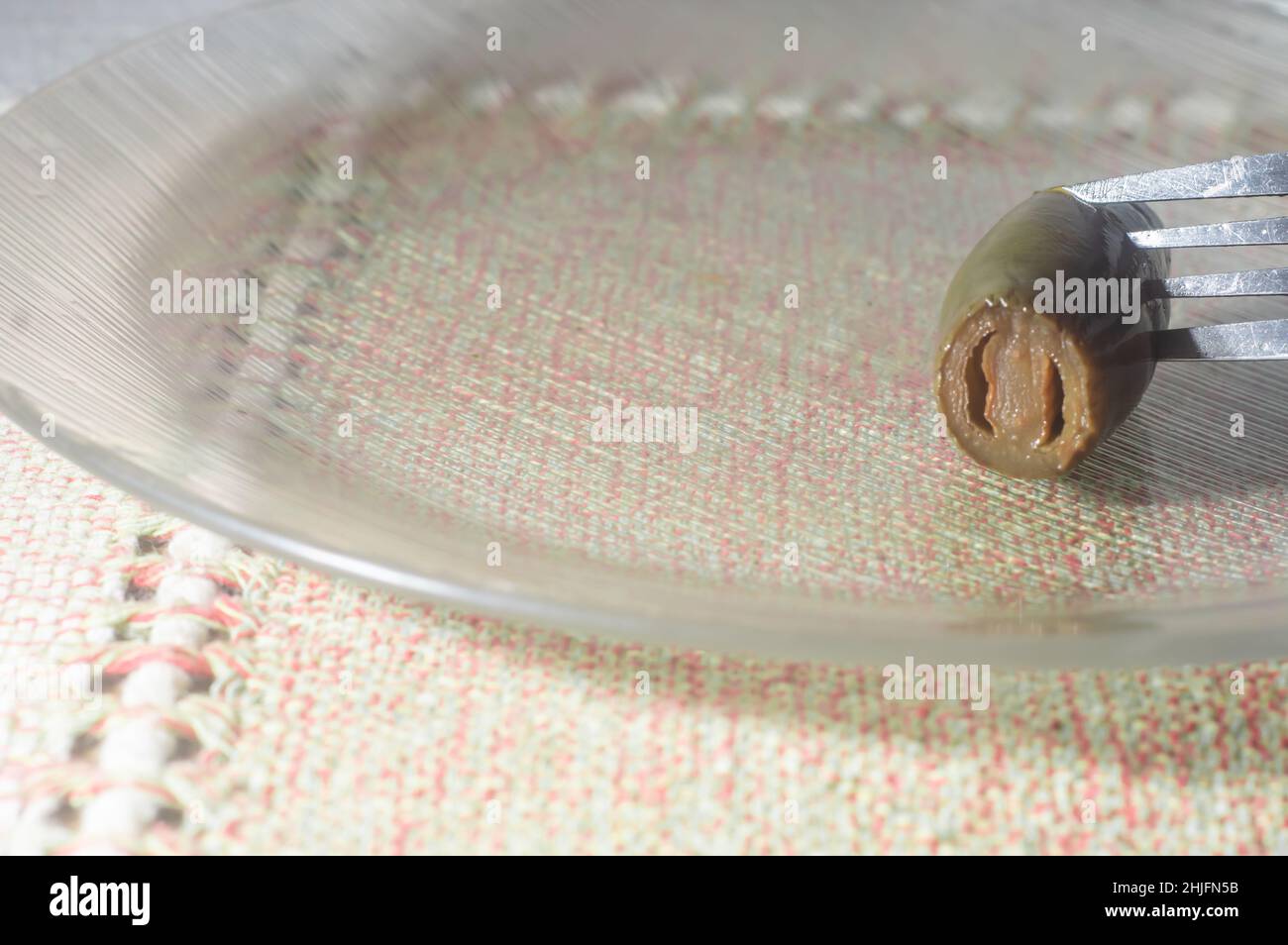 Jalapeno-Pfeffer auf einem Teller mit mao-Holding, eingelegter Pfeffer wird zerknittert, kopieren Sie Platz links. Stockfoto