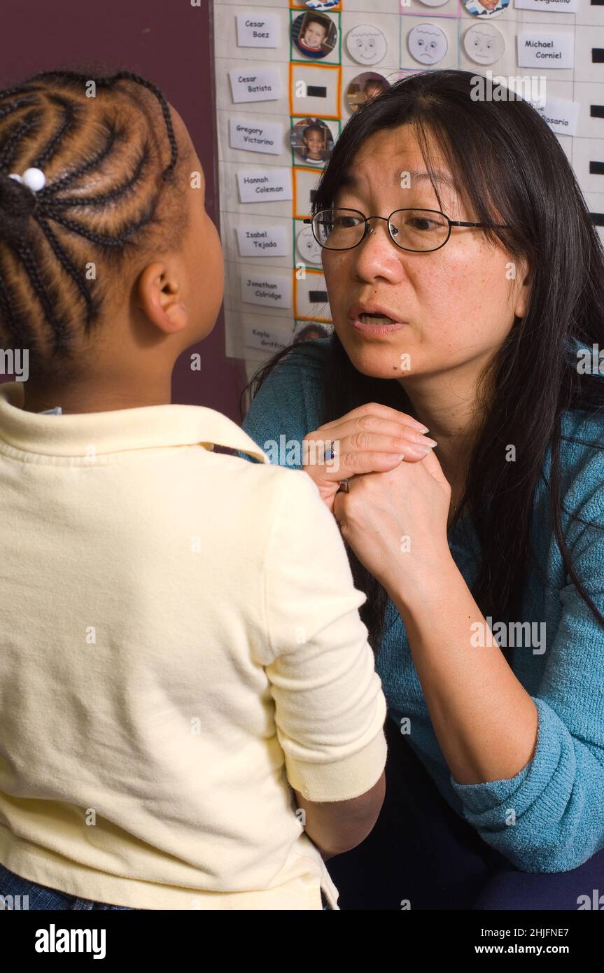 Bildung Vorschule Klassenzimmer 4-5-jährige Lehrerin im Gespräch mit Mädchen, Diskussion über Verhalten oder Klassenkampf Stockfoto