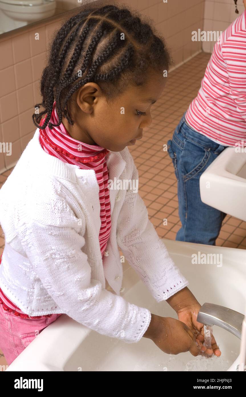 Bildung Vorschule Klassenzimmer im Alter von 4-5 Jahren Mädchen waschen ihre eigenen Hände am Waschbecken im Badezimmer Stockfoto