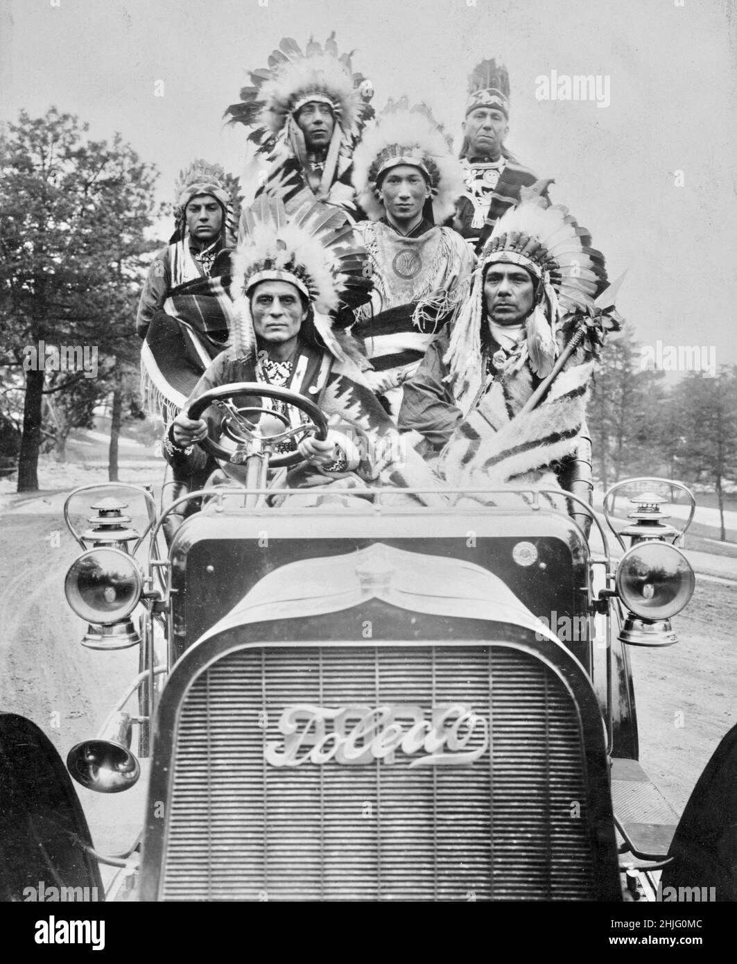 Edwin Levic Foto mit dem Titel Indians in an Automobile - Foto zeigt sechs indianische Männer in traditioneller Kleidung in einem Auto von Papst-Toledo. Stockfoto