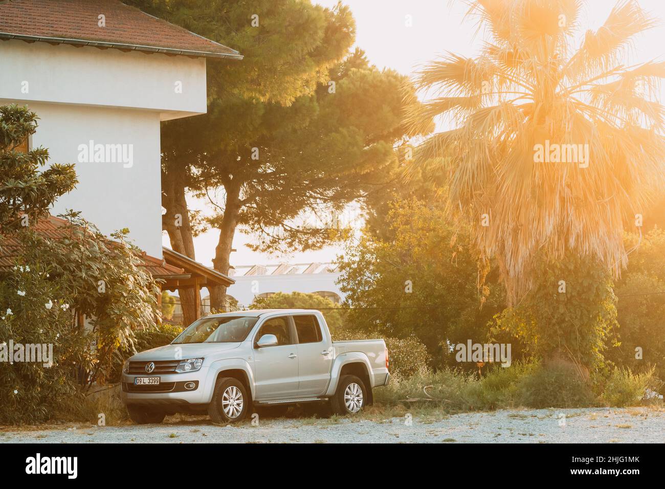 Grauer Volkswagen Amarok Pickup-Truck, der während des Sommeruntergangs auf dem Land geparkt ist. Stockfoto