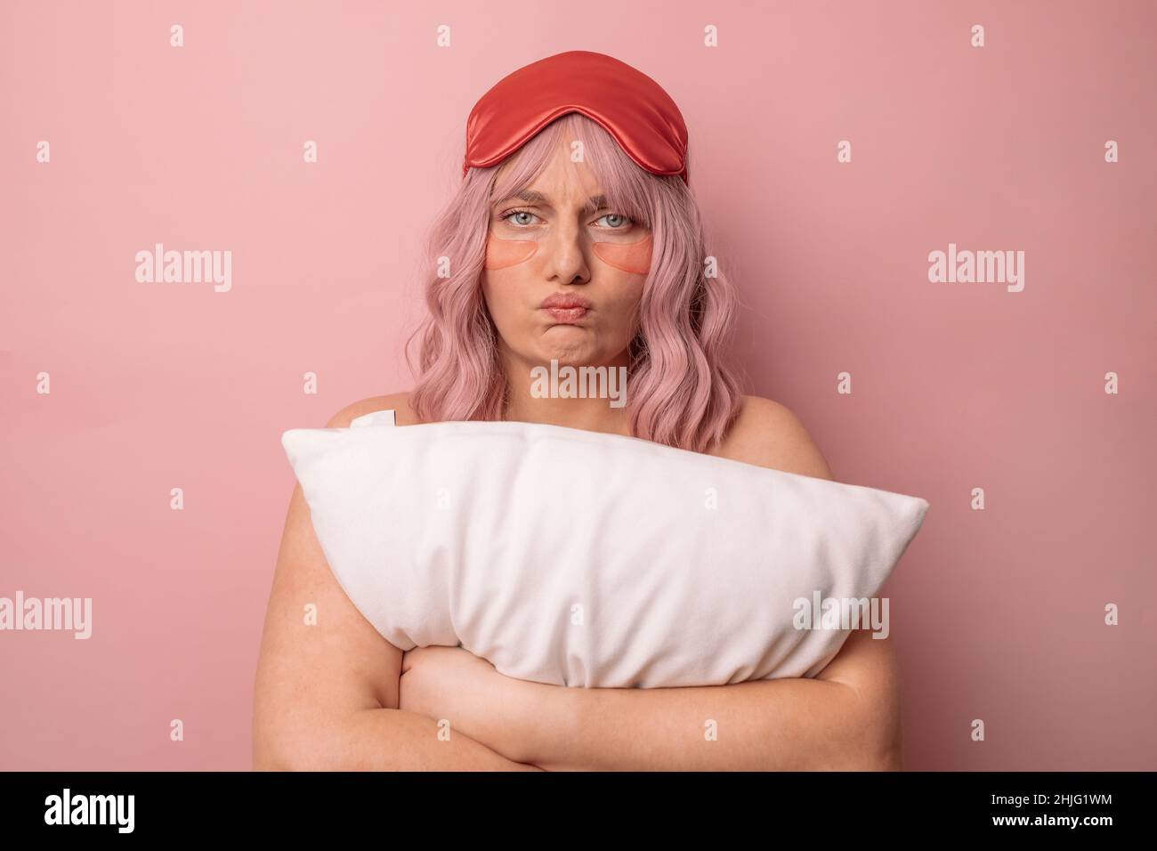 Verärgert schläfrig kaukasische Frau trägt Schlafmaske, traurig, früh morgens aufzuwachen Posen isoliert über rosa Hintergrund. Stockfoto