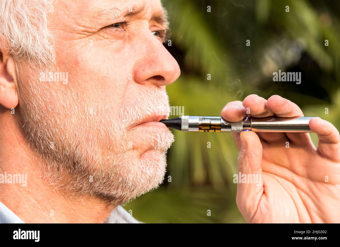 Porträt eines erwachsenen älteren Mannes, der elektronische Zigarette raucht. Stockfoto