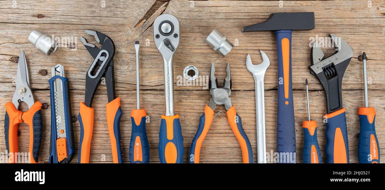 Arbeitswerkzeug Reparatur Service Handyman Hardware auf Holz, Banner, Draufsicht. DIY, Home Maintenance, Toolkit. Stockfoto