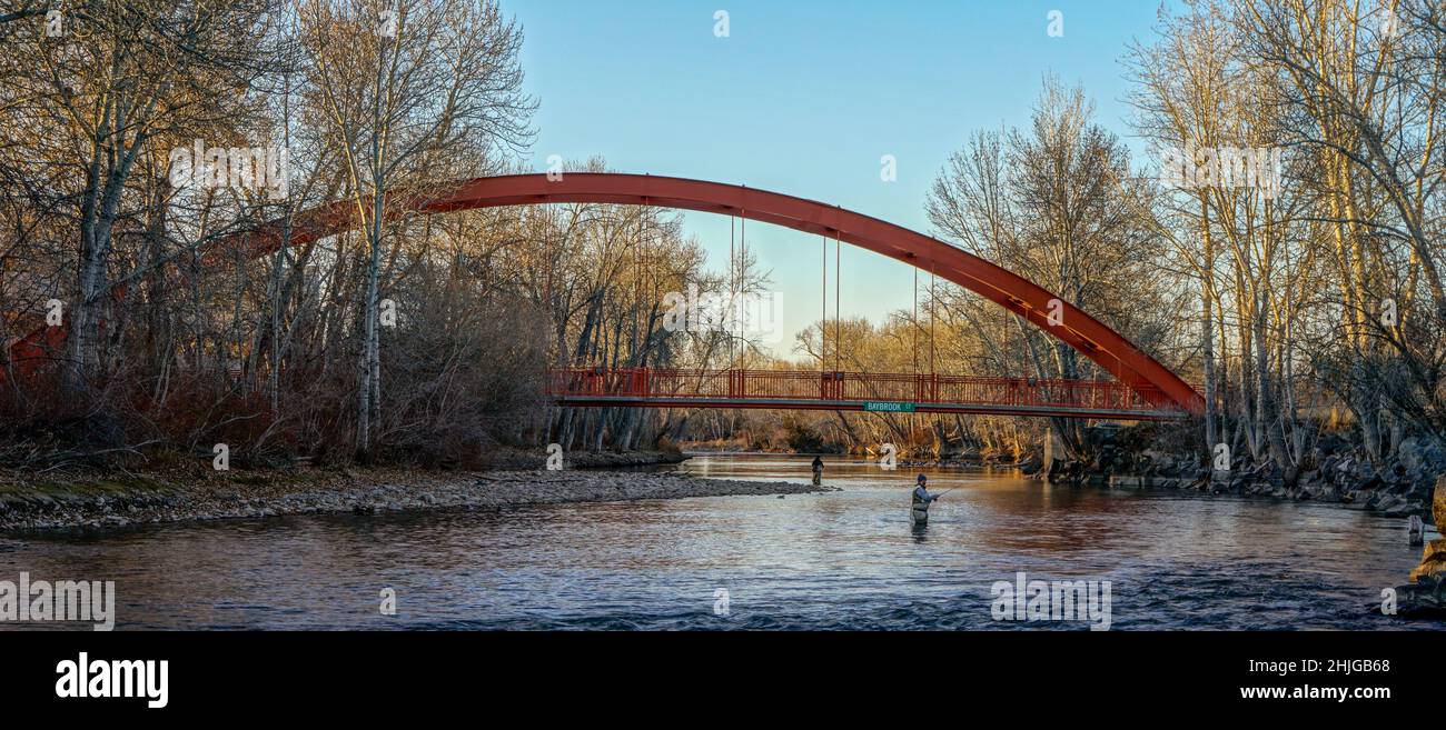 Zwei Männer fischen im Boise River unterhalb der Baybrook Court Fußgängerbrücke an einem Winternachmittag. Stockfoto