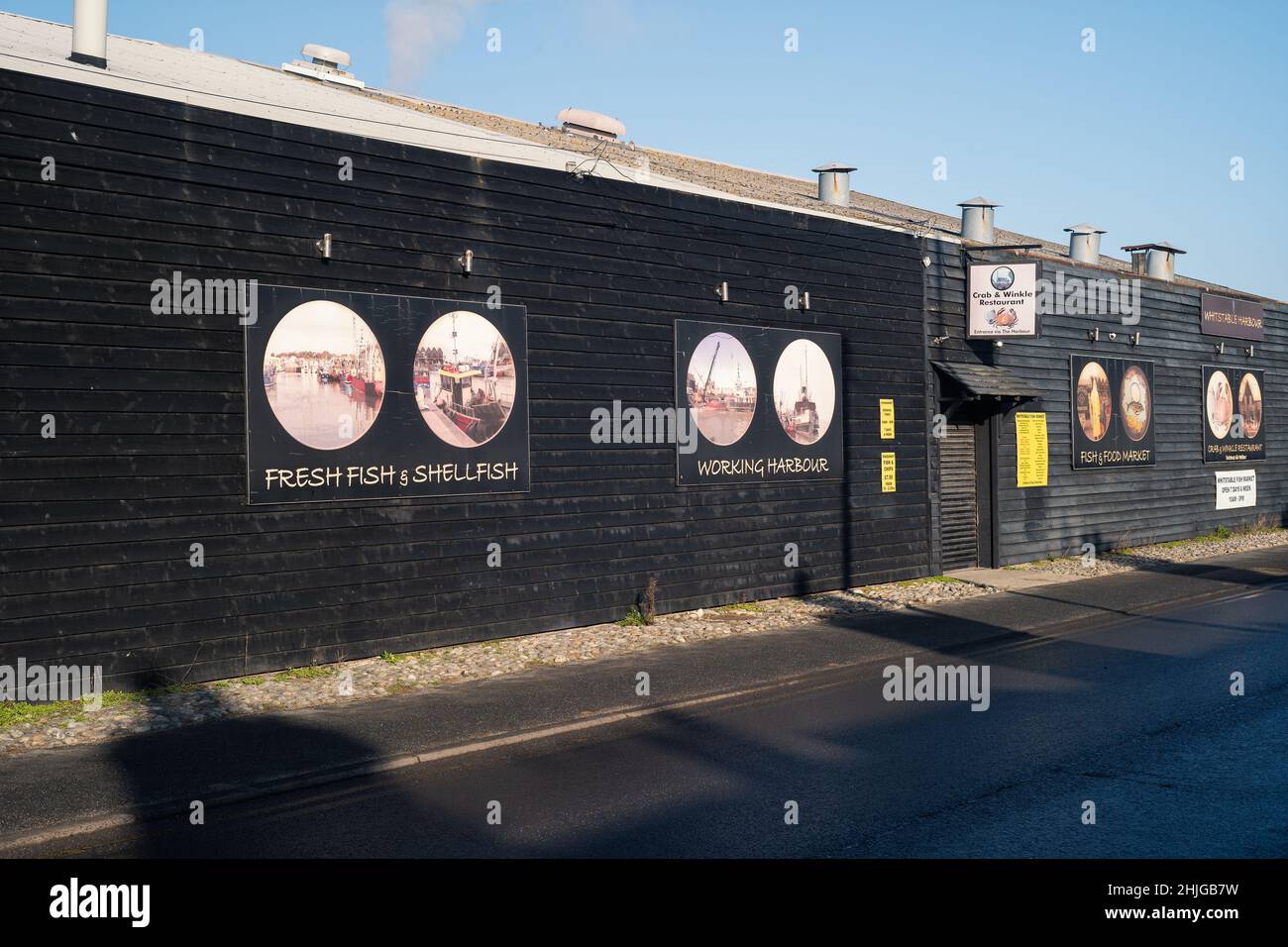 Whitstable, Großbritannien - Jan 18 2022 das ikonische schwarze Holz auf der Rückseite der Gebäude, in denen sich die Restaurants und der Fischmarkt im Hafen von Whitstable befinden, ist zu sehen Stockfoto