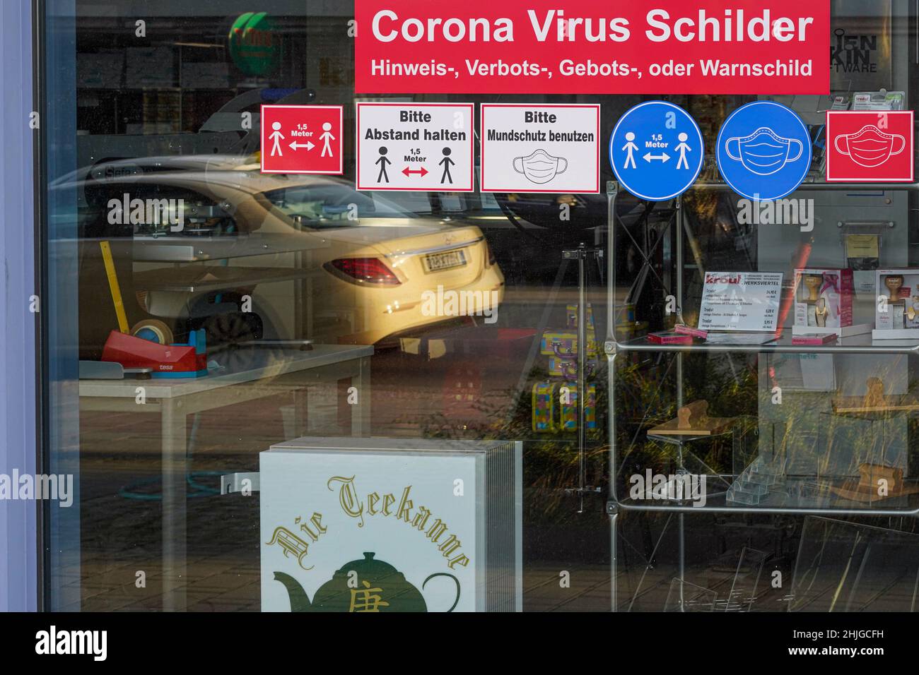 Am Schaufenster eines Ladens werden Corona Virus-Schilder zum Verkauf angeboten: Hinweisschilder, Verbotsschilder, Pflichtschilder oder Warnschilder. Stockfoto