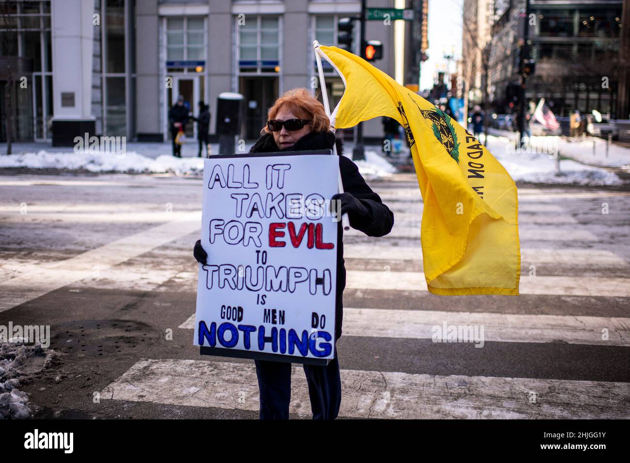 Ein Demonstrator hält am Samstag, dem 29. Januar 2022 in Chicago, IL, ein Schild und eine Gadsden-Flagge bei der Kundgebung gegen COVID-19-Impfstoff und Maskenmandate. (Foto von Christopher Dilts / Sipa USA) Stockfoto