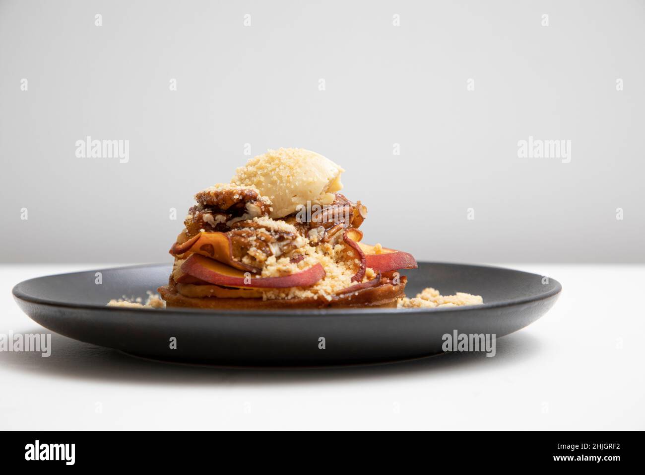 Pfirsich-Schuster mit gerinnter Creme und kandierten Pekannüssen Stockfoto