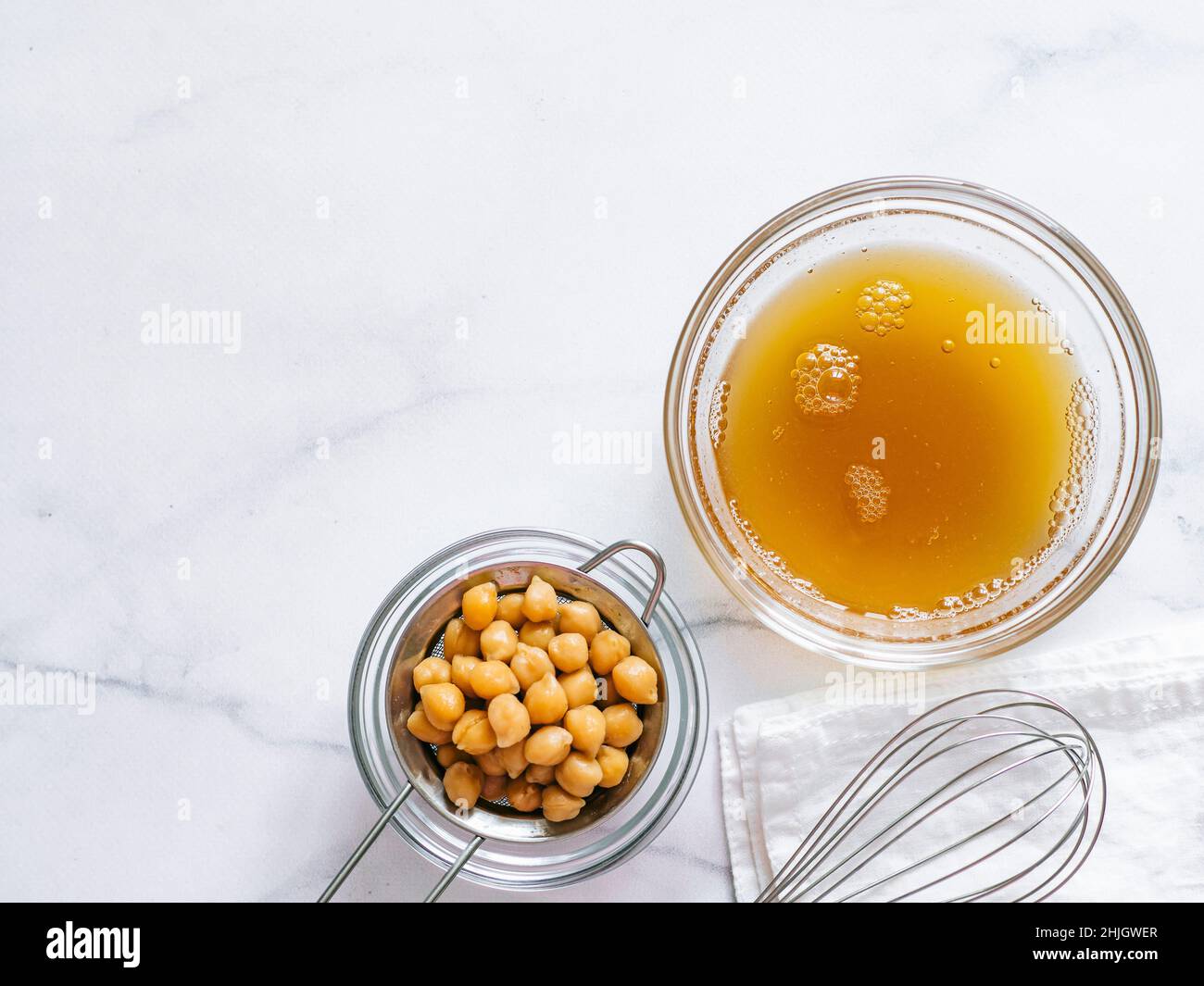 Aquafaba in einer Schüssel. Kichererbsen Wasser Sole aquafaba . Eierersatz beim Gurren. Veganes Konzept. Ansicht von oben oder flach liegend. Speicherplatz kopieren Stockfoto