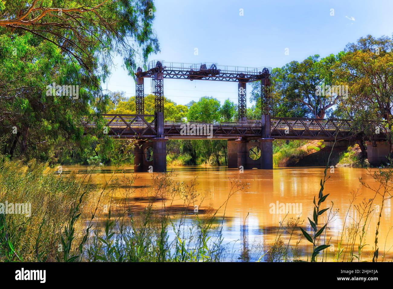 An einem heißen Sommertag teilt die Eisenbahn die Brücke über den Darling River in Wilcannia, der Stadt Outback australia. Stockfoto