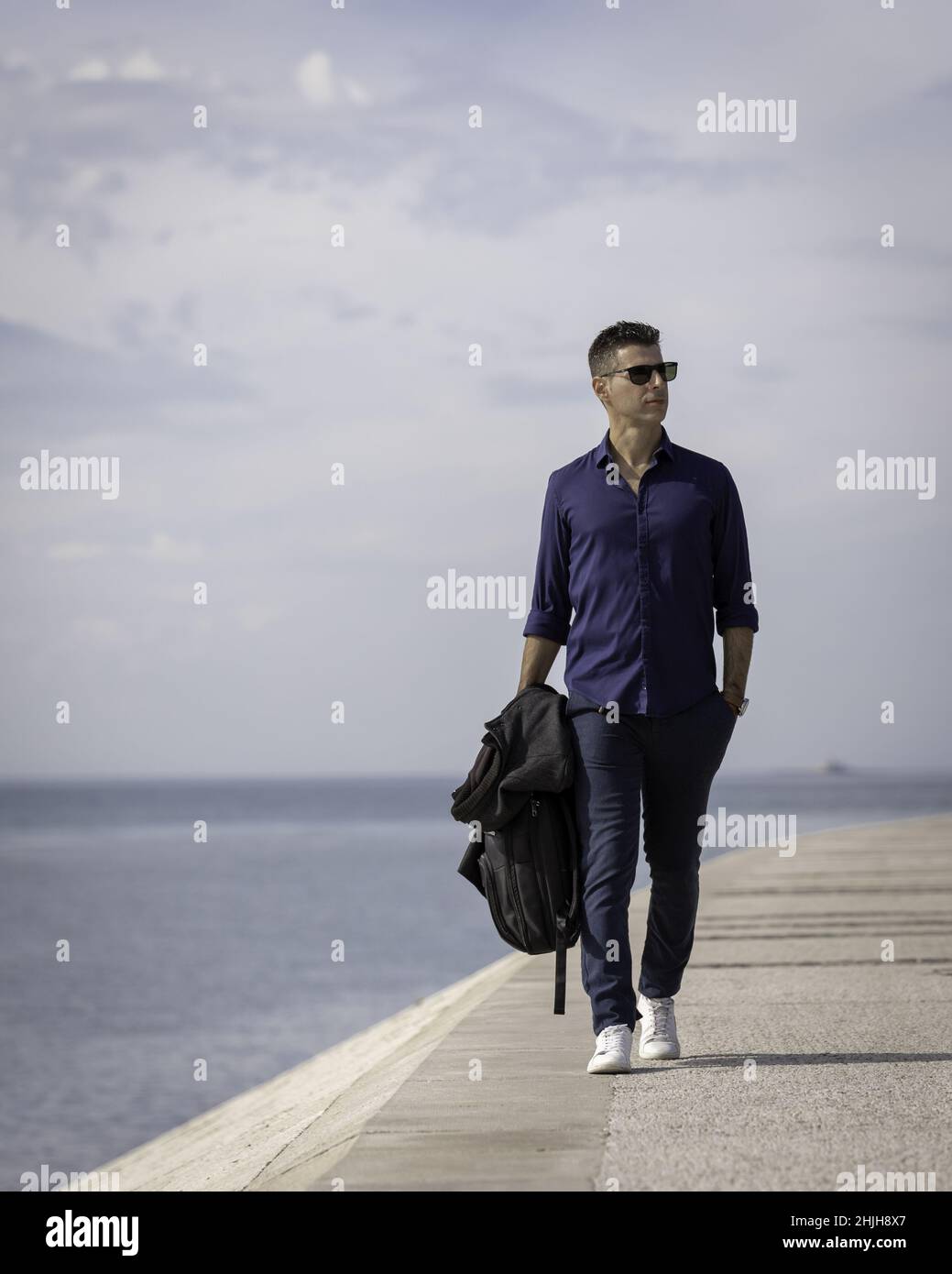 Ein junger, eleganter Unternehmer, der alleine am Lissabonner Ufer in Portugal unterwegs ist Stockfoto
