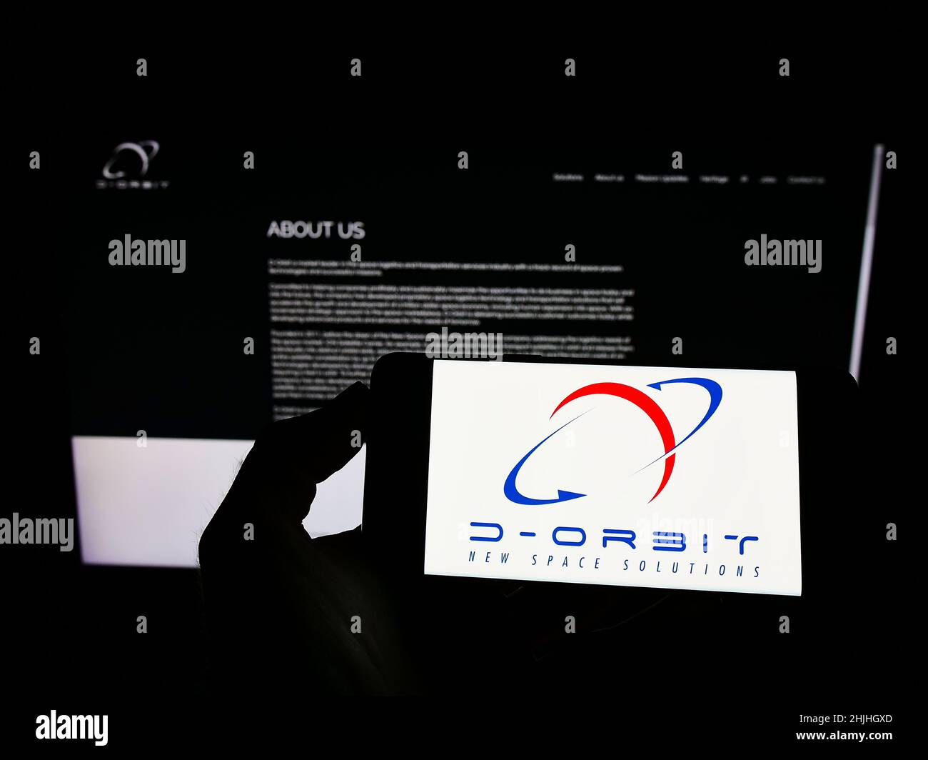 Person mit Mobiltelefon und Logo des italienischen Luftfahrtunternehmens D-Orbit Spa auf dem Bildschirm vor der Business-Webseite. Konzentrieren Sie sich auf die Telefonanzeige. Stockfoto