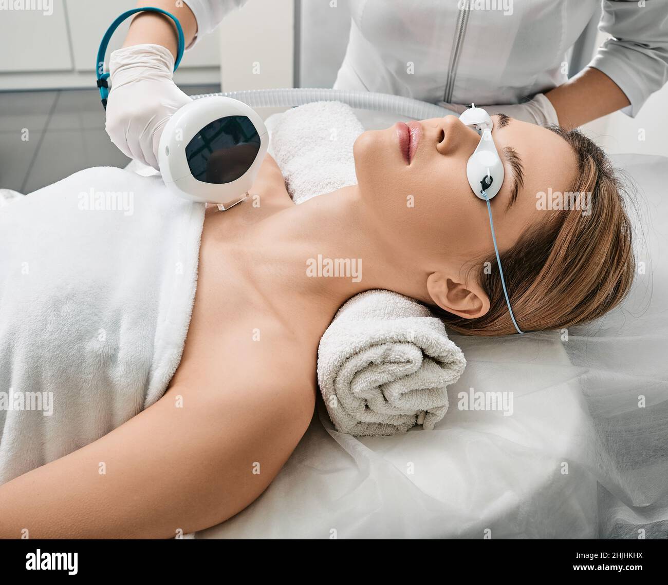 Entfernung von braunen Flecken und Sommersprossen am Körper und am Ausschnitt einer Frau bei der Kosmetologie mit einer Maschine mit intensiv gepulster LichtIPL-Technologie Stockfoto
