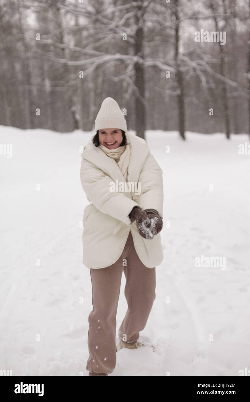 Zwei Mädchen spielen im Winter Schneebälle im Schnee in einer warmen Winterkleidung Stockfoto