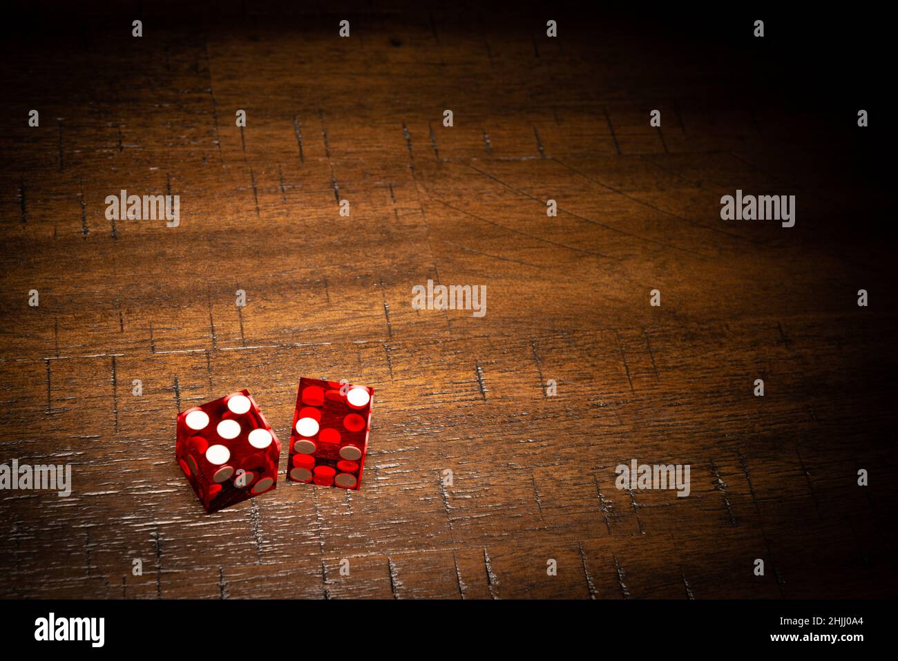 Professionelle Würfel im Casino-Stil auf einem Holztisch unter einer High-Key-Beleuchtung. Stockfoto