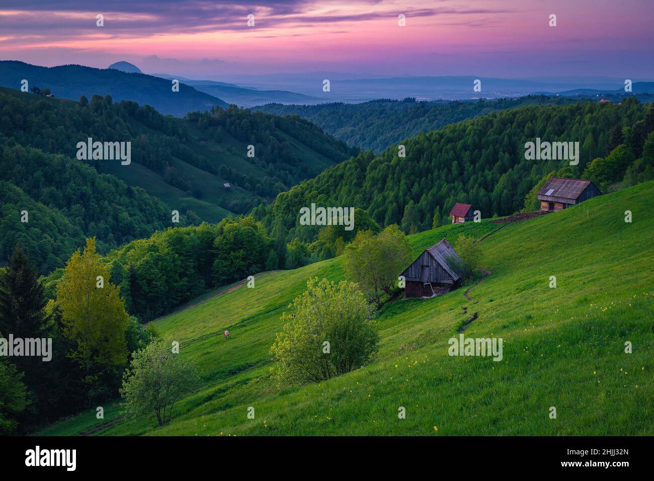 Holzhütten auf dem Hügel in der Wildnis. Landschaft bei Sonnenuntergang, Siebenbürgen, Rumänien, Europa Stockfoto