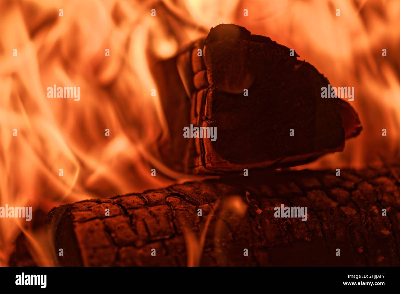 Nahaufnahme des Brennholzes, das in roten Flammen des Feuers im Kamin brennt Stockfoto
