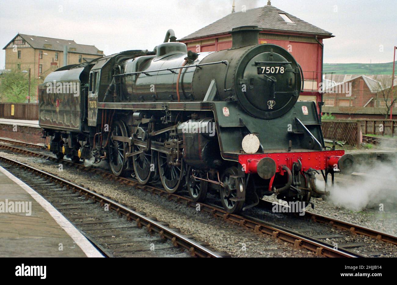 British Railways Standard Class 4MT 4-6-0 Tender-Dampflokomotive erwartet den nächsten Zug am Keighley-Bahnhof auf dem KWVR in den 1990er Jahren Stockfoto