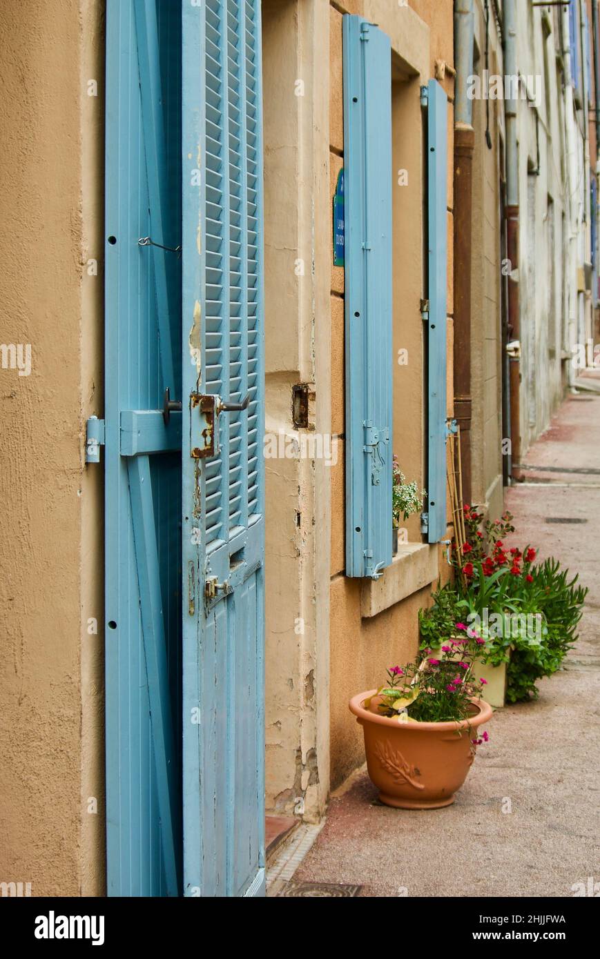 Stadthaus mit blauer Tür und blauen Fensterläden in einem kleinen Dorf in der Provence in Frankreich. Stockfoto