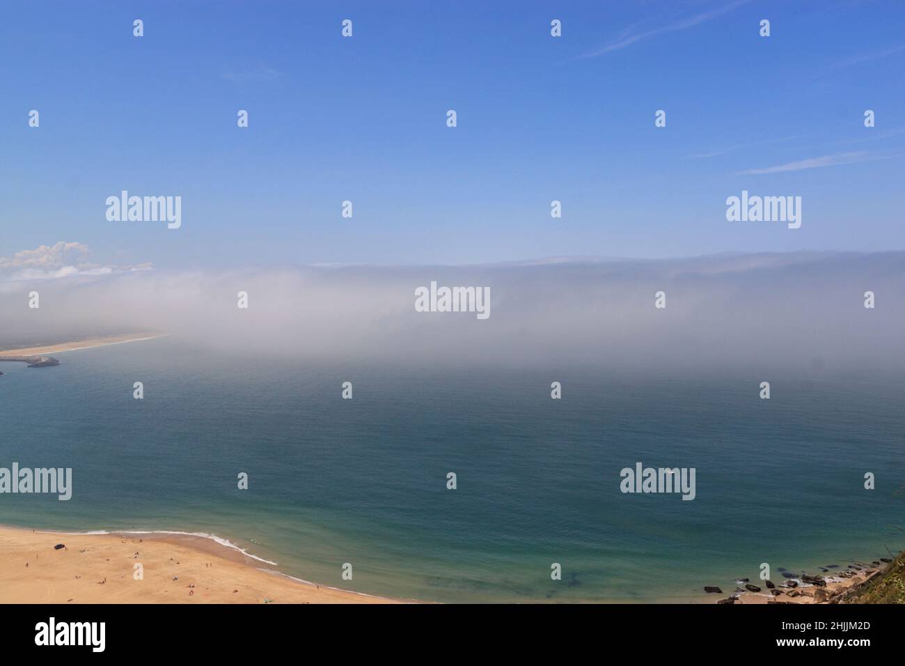 Schöner Blick auf den Nazare-Strand. Küste des Atlantischen Ozeans. Portugiesische Küstenstadt an der Silberküste. Die Wolken über dem Wasser sind wie Tsunami-Wellen. Stockfoto