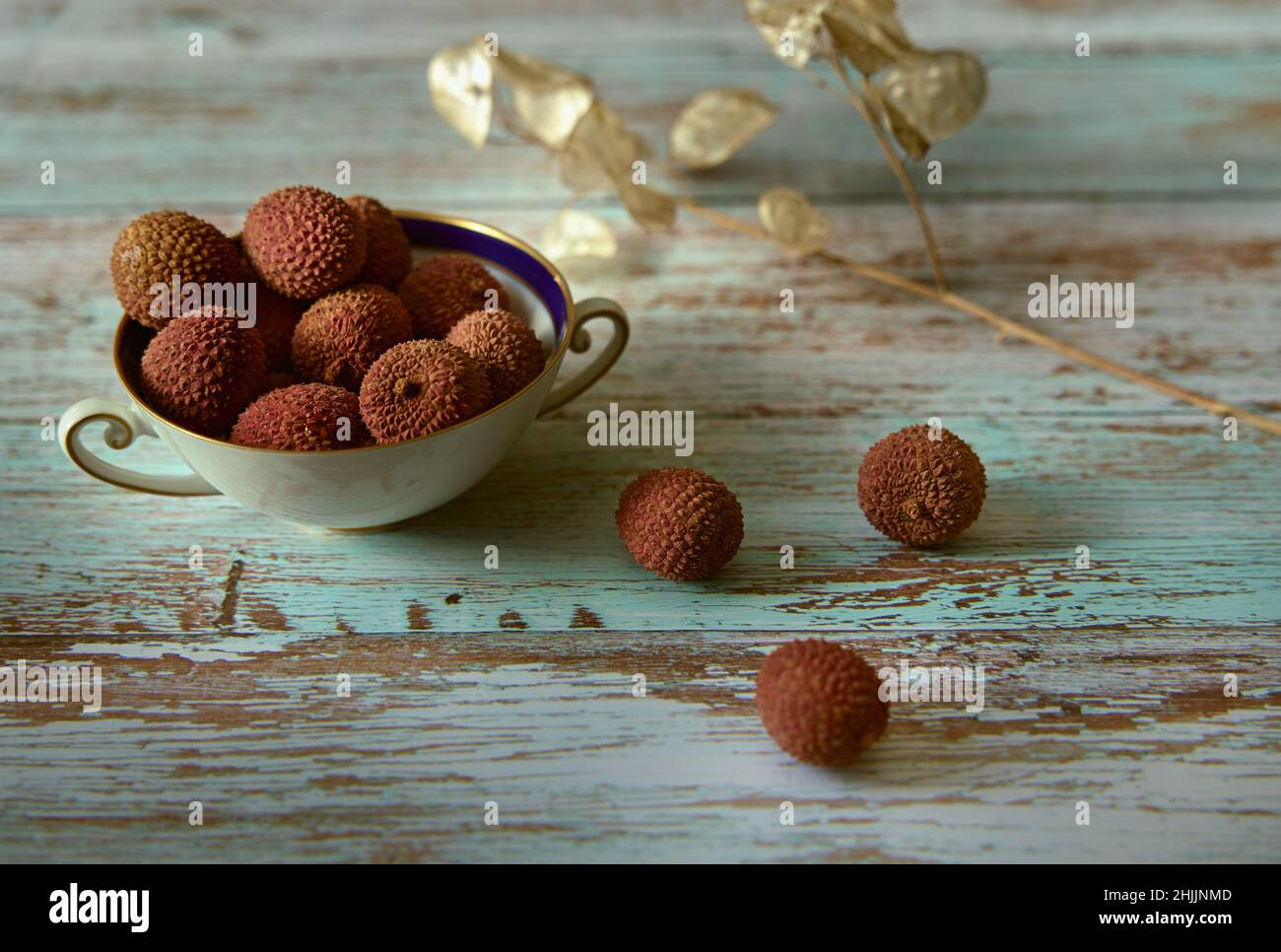 Litchi oder chinesische Pflaume in einer weißen Keramikschale auf einem Holztisch. Stockfoto