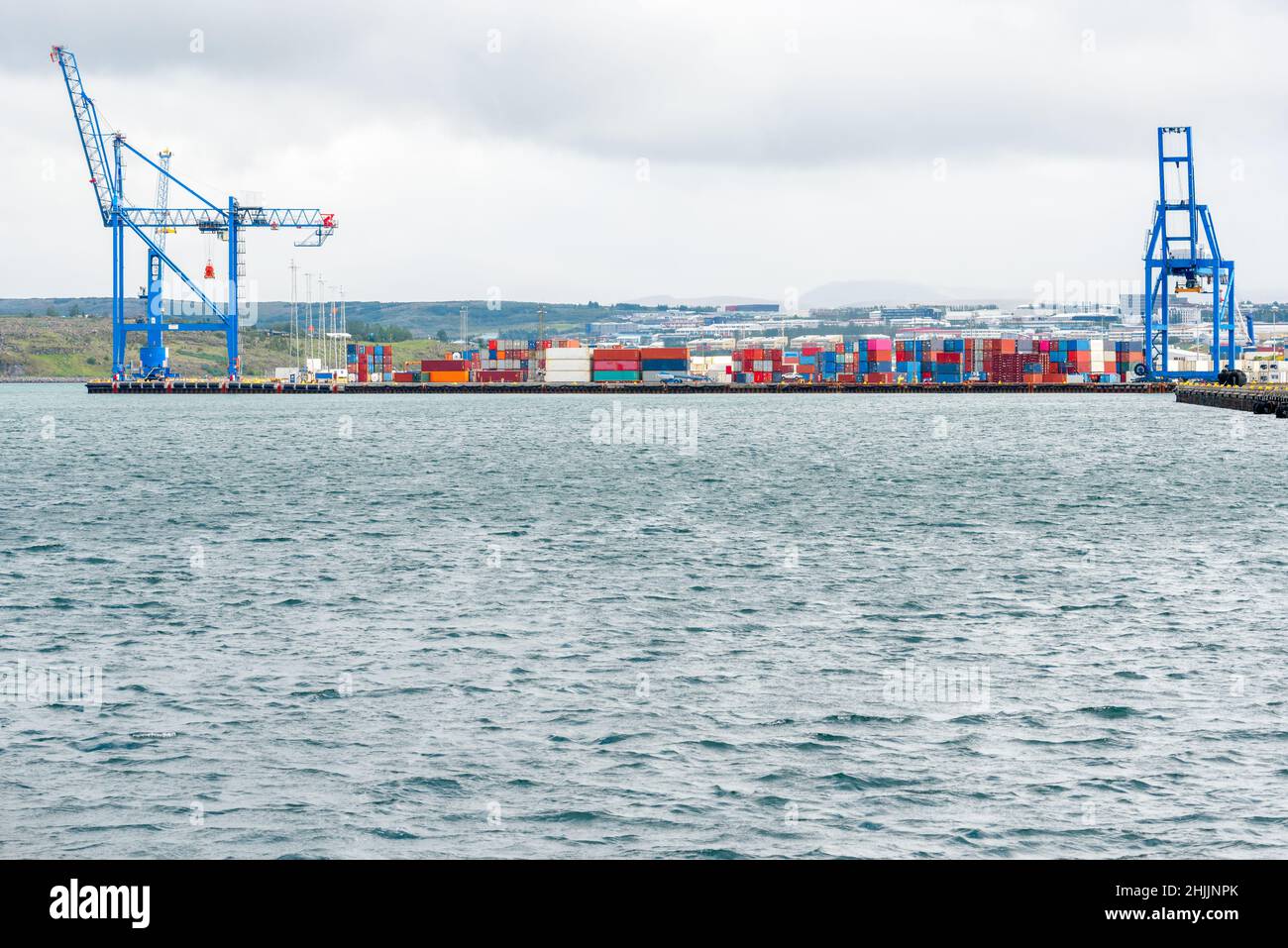 Farbenfrohe Container an einem Pier in einem verlassenen Handelshafen an einem bewölkten Tag Stockfoto