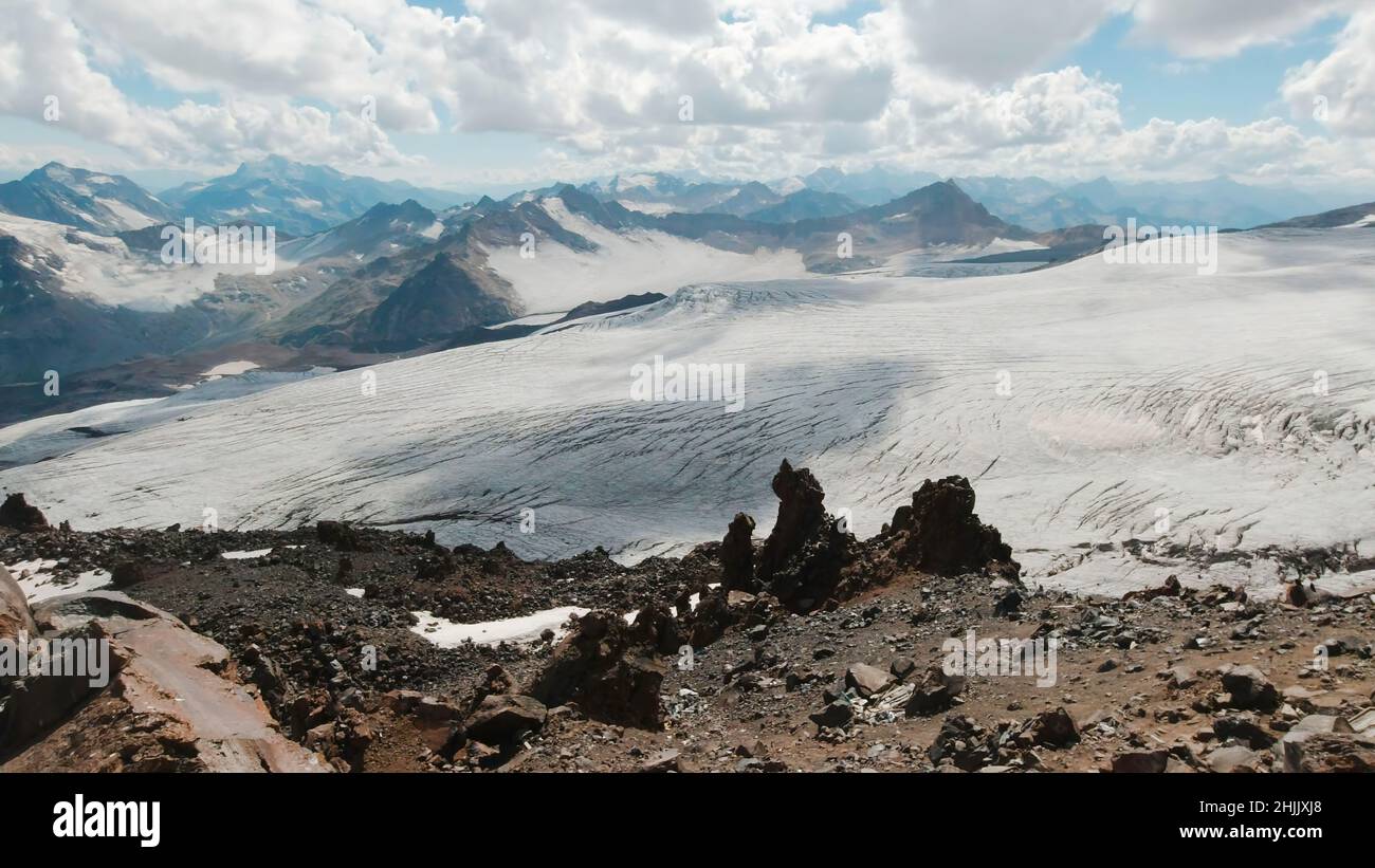 Wunderschöne Berglandschaft mit Felsen und schneebedeckten Gipfeln. Clip. Wunderschöne Steinberge mit schneebedeckten Gipfeln an sonnigen Tagen. Außerirdische Landschaft Stockfoto
