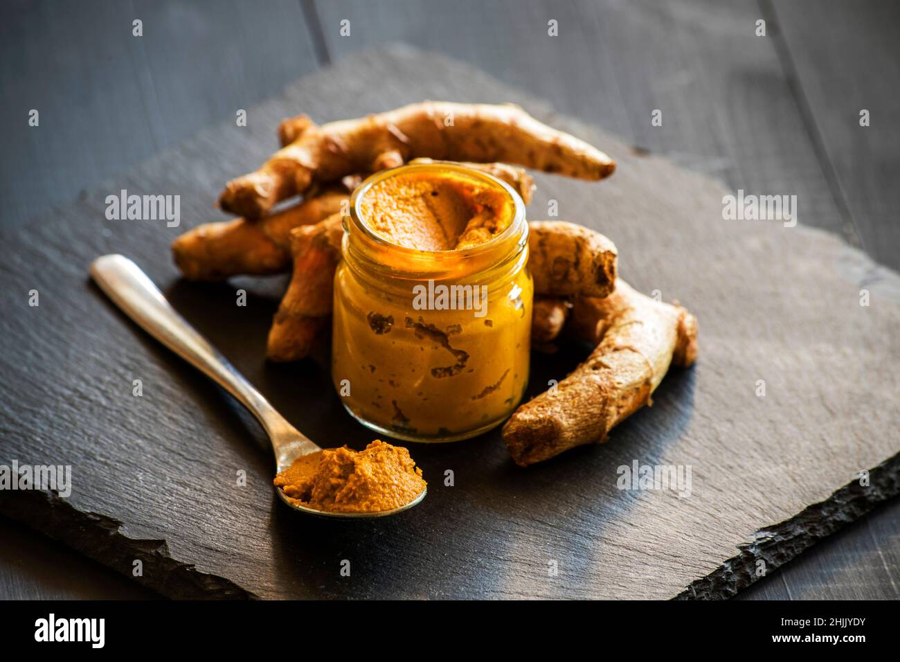 Kurkuma-Paste mit Kurkuma-Wurzel, Bestandteil der ajurvedischen Medizin goldene Milch Stockfoto