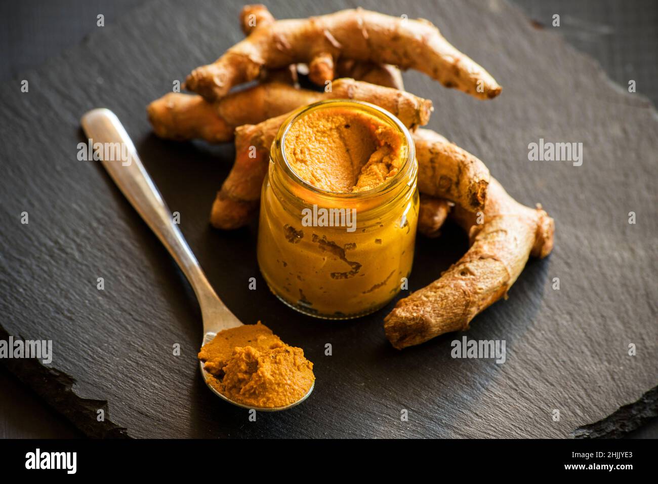 Kurkuma-Paste mit Kurkuma-Wurzel, Bestandteil der ajurvedischen Medizin goldene Milch Stockfoto