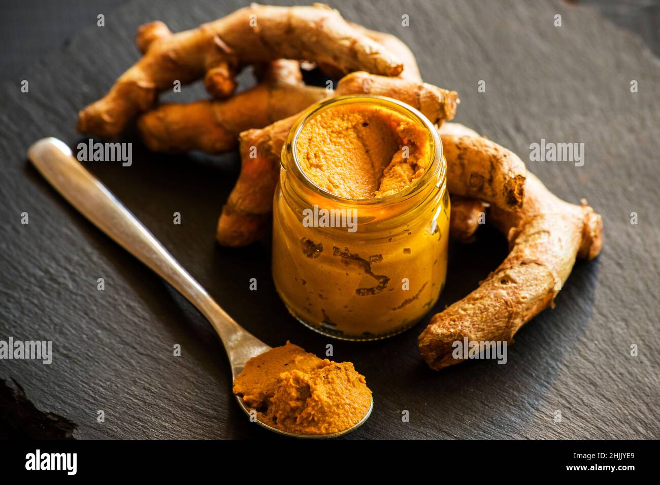 Kurkuma-Paste mit Kurkuma-Wurzel, Bestandteil der ajurvedischen Medizin goldene Milch Stockfoto