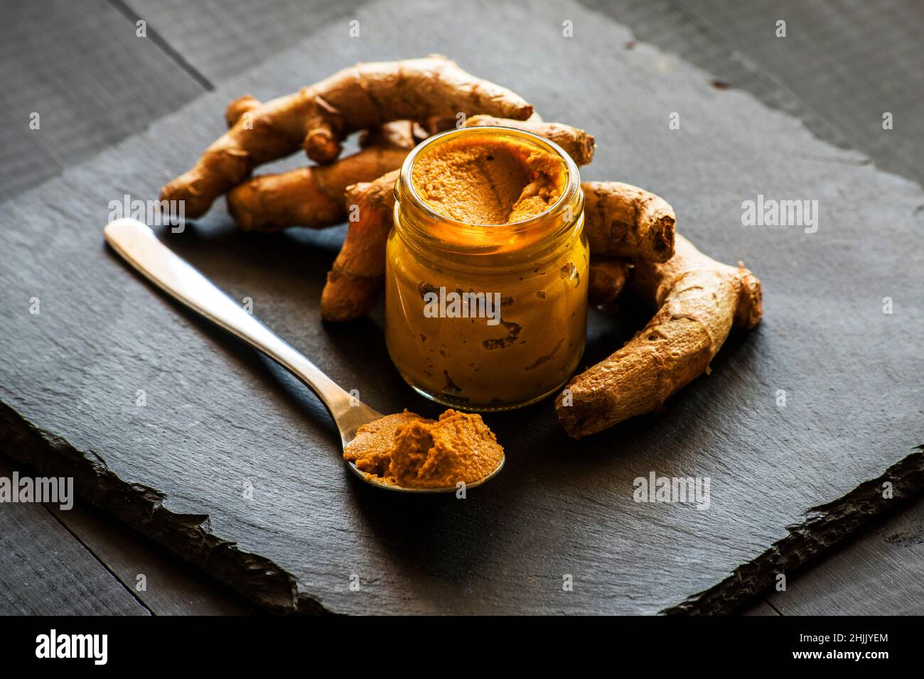 Kurkuma-Paste mit Kurkuma-Wurzel, Bestandteil der ajurvedischen Medizin goldene Milch Stockfoto