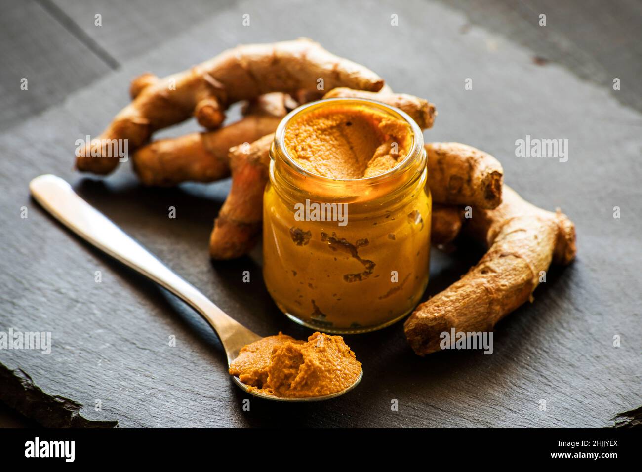 Kurkuma-Paste mit Kurkuma-Wurzel, Bestandteil der ajurvedischen Medizin goldene Milch Stockfoto