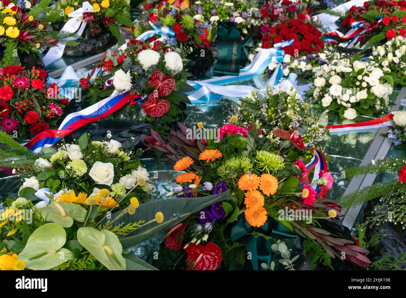 Amsterdam, Niederlande. 30. Januar 2022. Nahaufnahme der farbenfrohen Blumenkränze und Bänder, die das Auschwitz-Denkmal der gebrochenen Spiegel am Nationalen Holocaust-Gedenktag bedecken. Kredit: Steppeland/Alamy Live Nachrichten Stockfoto