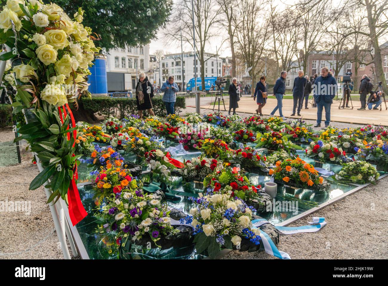 Amsterdam, Niederlande. 30. Januar 2022. Menschen, die die Blumenkränze betrachten, die das Auschwitz-Denkmal (auch als Spiegelmonument „Never More Auschwitz“ oder „Broken Mirrors“ bekannt) im Amsterdamer Wertheim Park am Nationalen Holocaust-Gedenktag bedecken. Kredit: Steppeland/Alamy Live Nachrichten Stockfoto