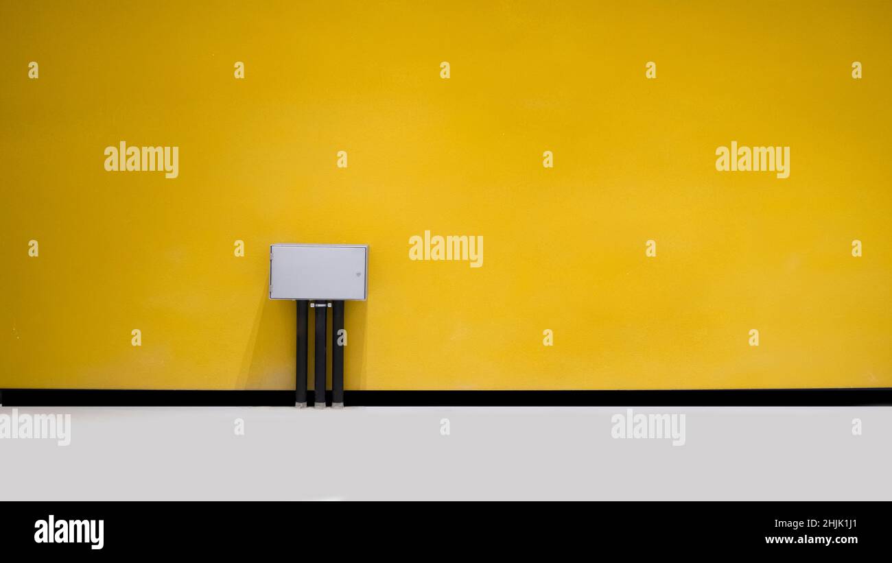 Elektrokästen vor der isolierten Wand Stockfoto