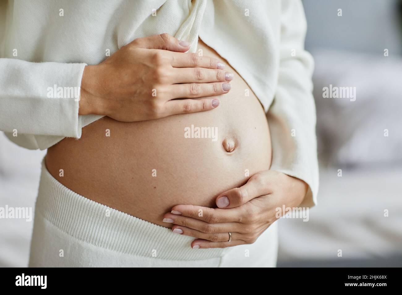 Nahaufnahme einer jungen Schwangeren, die ihren Bauch berührt und sich um ihre Gesundheit kümmert Stockfoto